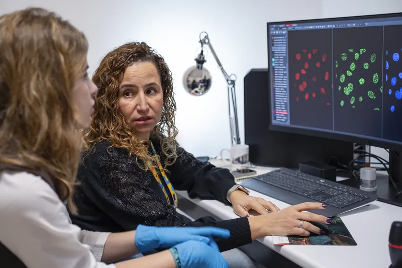 Dos investigadoras analizan imágenes de microscopía de fluorescencia
